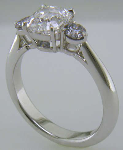 An Asscher-cut Diamond set with two Blue-Violet Round Diamonds in a hand-crafted platinum ring.
