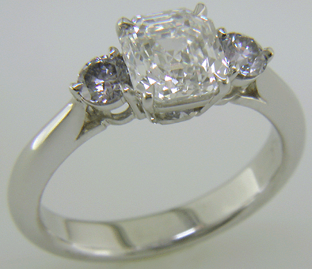 An Asscher-cut Diamond set with two Blue-Violet Round Diamonds in a hand-crafted platinum ring.