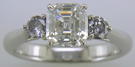 An Asscher-cut Diamond set with two Blue-Violet Round Diamonds in a hand-crafted platinum ring.