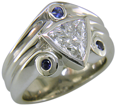 A trilliant diamond ring with three small sapphires.