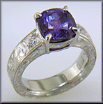 A cushion-cut Sapphire set in a beautifully hand crafted and engraved platinum ring.