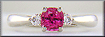 Cushion-cut Pink Sapphire set with two round diamonds in a hand-crafted platinum ring.
