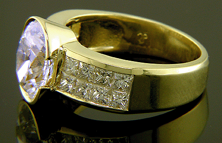 18kt gold ring with oval center diamond and 16 princess-cut diamonds.