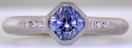Flanders-cut Sapphire with round diamonds in a custom platinum ring.