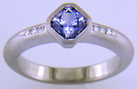Flanders-cut Sapphire with round diamonds in a custom platinum ring.