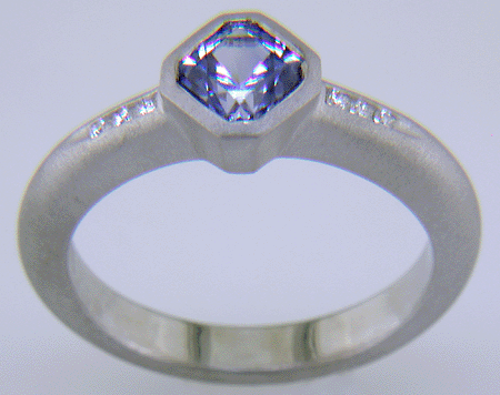 Flanders-cut Sapphire with round diamonds in a custom platinum ring.