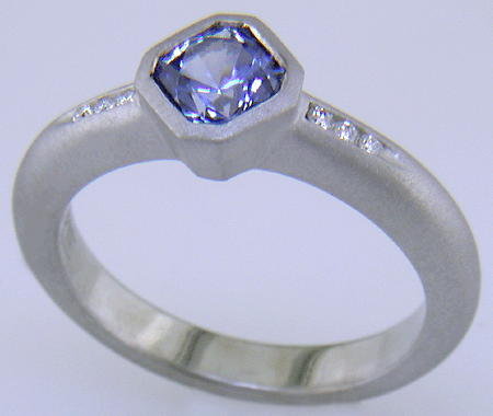 Flanders-cut Sapphire with round diamonds in a custom platinum ring.