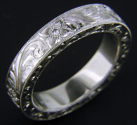 Hand engraved platinum band set with diamonds