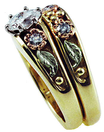 Side view of custom wedding rings crafted in yellow rose and green gold