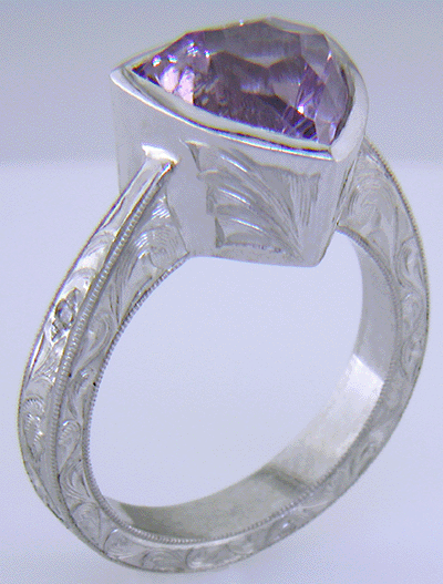 Concave-faceted Amethyst set in an engraved platinum ring. (J7415)