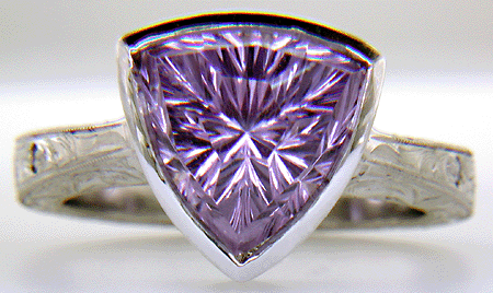 Concave-faceted Amethyst set in an engraved platinum ring. (J7415)