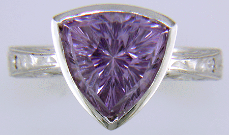 Concave-faceted Amethyst set in an engraved platinum ring. (J7415)