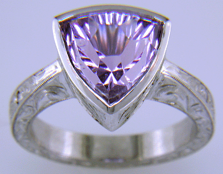 Concave-faceted Amethyst set in an engraved platinum ring. (J7415)
