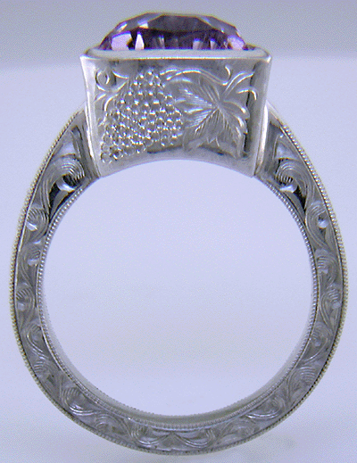Concave-faceted Amethyst set in an engraved platinum ring. (J7415)