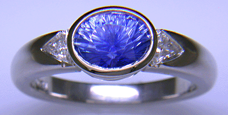 Concave-faceted sapphire and trilliant diamonds in a custom platinum ring.