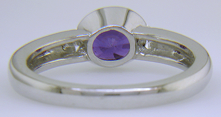 Inside view of oval sapphire ring with trilliant diamonds crafted in platinum.