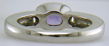 Inside view of violet sapphire ring with trilliant diamonds crafted in platinum.