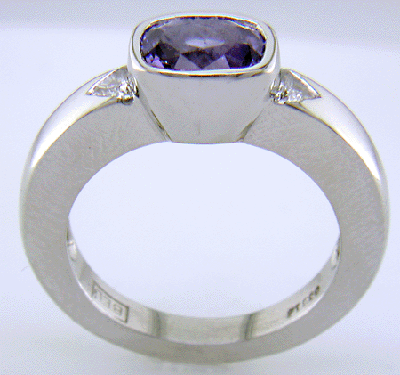 Side view of violet sapphire ring with trilliant diamonds crafted in platinum.