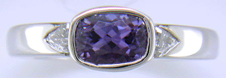 Violet sapphire with trilliant diamonds in custom platinum ring.