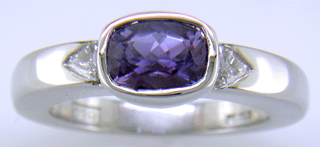 Violet sapphire with trilliant diamonds in a custom platinum ring.