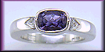 Violet sapphire with trilliant diamonds in a custom platinum ring.