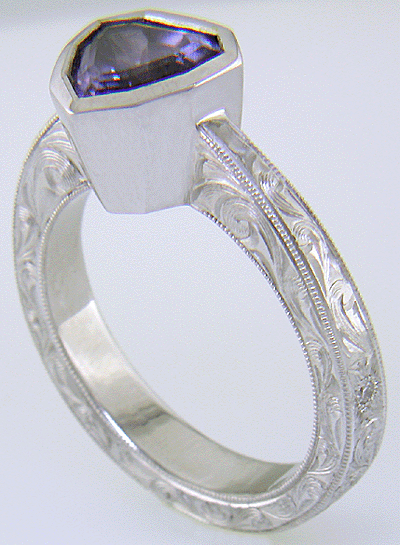 Hand engraved platinum ring with a shield-shape Lavender Spinel. (J8710)