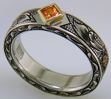 A beautifully hand-engraved ring set with fiery orange Manderin Garnets. (J8703)