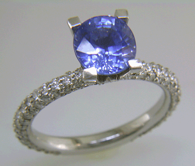 Sapphire set with pave diamonds in a platinum ring.