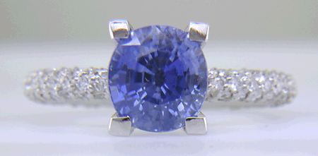 Sapphire set with pave diamonds in a platinum ring.