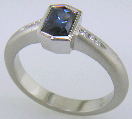 Morph-cut Sapphire with round diamonds in a custom platinum ring. (J8543)
