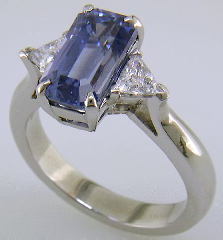 A hand-crafted platinum ring with a emerald-cut pastel Sapphire and sparkling diamonds. (J8541)