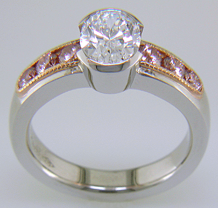 Oval Diamond set with 6 brilliant Pink Diamonds in a custom rose gold and platinum ring.