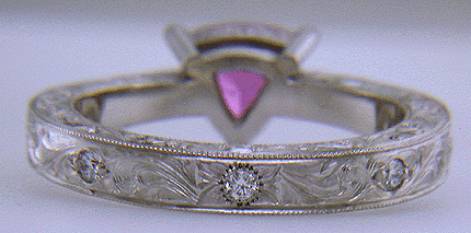 Base view of hand engraved platinum ring with a trillium pink sapphire.