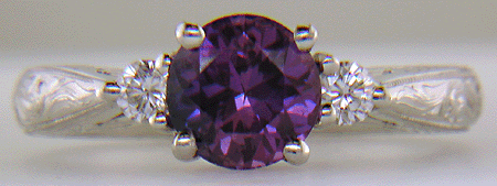 Purple Sapphire set with two round diamonds in a hand-engraved platinum ring. (J8525)