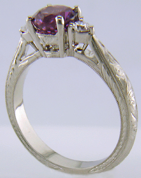 Side view of Purple Sapphire set with two round diamonds in a hand-engraved platinum ring. (J8525)
