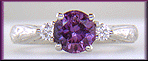 Purple Sapphire set with two round diamonds in a hand-engraved platinum ring.