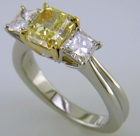 Fancy Intense Yellow diamond set with two radiant-cut diamonds in a custom platinum ring.