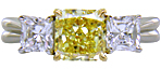 Fancy Intense Yellow diamond set with two radiant-cut diamonds in a custom platinum ring.