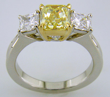 Fancy Intense Yellow diamond set with two radiant-cut diamonds in a custom platinum ring.