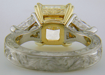 Inside view of engraved custom ring with a yellow radiant-cut diamond and trilliants.