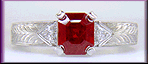 Emerald-cut ruby set with trilliant diamonds in a custom engraved platinum ring.