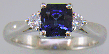 Emerald-cut sapphire set with two round diamonds in a hand-crafted platinum ring. (J8540)