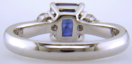Emerald-cut sapphire set with two round diamonds in a hand-crafted platinum ring. (J8540)