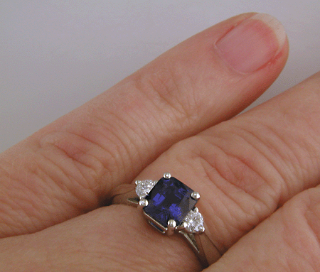 Emerald-cut sapphire set with two round diamonds in a hand-crafted platinum ring. (J8540)