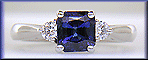 Emerald-cut sapphire set with two round diamonds in a hand-crafted platinum ring. (J8540)