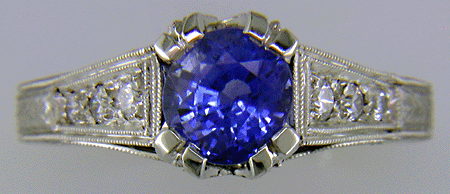 A bright sapphire set with 42 accenting diamonds in an engraved platinum ring.