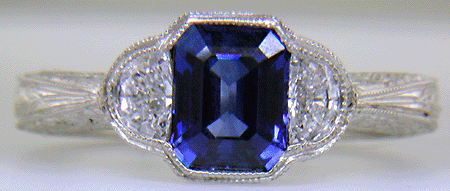 Emerald-cut saphire and half-moon diamond engraved ring.