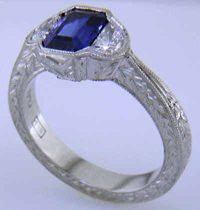 Emerald-cut saphire and half-moon diamond engraved ring.