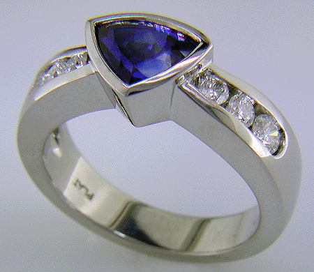 Channel set diamonds in trillium sapphire platinum ring. (J6413)