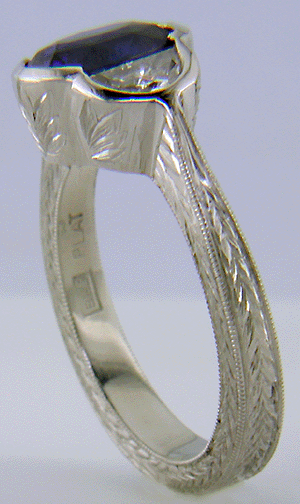 Oval saphire set with crescent moon diamonds in an engraved platinum ring. (J7269)